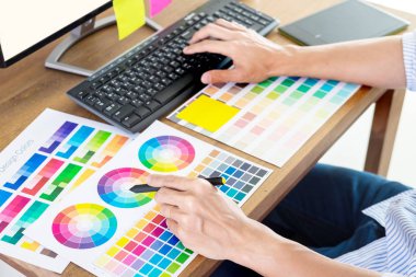 Grafik tasarımcı ve yaratıcı fare tutarak ve onun iş malzeme renk pantone renk örneği örnekleri sanat araçları Office masasında yapın 