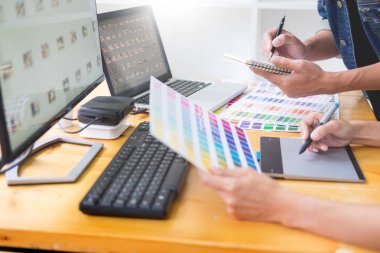 Tablet ve kalem, içinde meşgul yaratıcı bürolar kullanarak resmi düzenleme renk örneklerini kullanarak web tasarım grafik tasarımcı ekibi