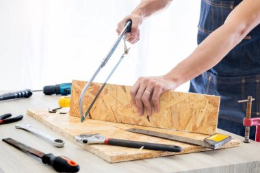 Marangoz, marangozluk planları eser dikkatle bakarak çalışma. Onun işyerinde başarılı bir girişimci olduğunu. Destekler üzerinde inşaat alanında iş kesici ile çivi çekiç