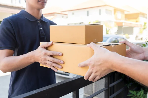 Levering aan huis service levert pakket thuis en vrouw receivi — Stockfoto