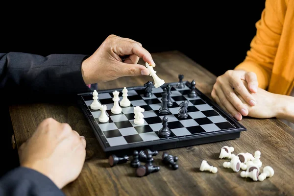 hand of businessman moving chess figure in competition board gam