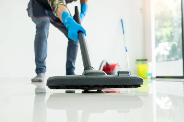 Young attractive man is cleaning vacuum commercial cleaning equi — Stock Photo, Image
