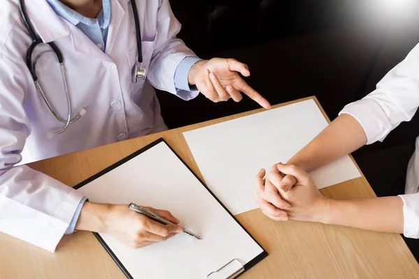 Paciente escuchando atentamente a un médico masculino explicando — Foto de Stock