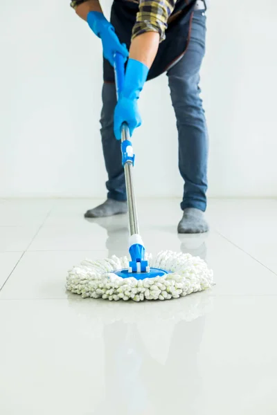 Young housekeeper cleaning floor mobbing holding mop and plastic — Stock Photo, Image