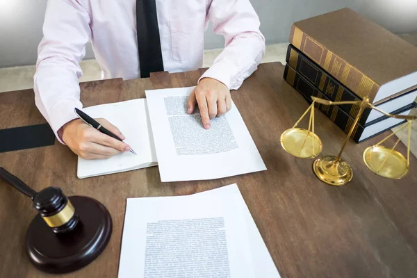 Abogado juez lectura de documentos en el escritorio en la sala de tribunal trabajando en fondo escritorio de madera. martillo dorado Peso. y bloque de sonido de la justicia —  Fotos de Stock