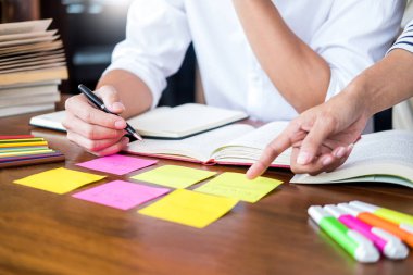 Genç öğrenciler sınıf çalışma kitabı yakalamak ve bir Kütüphane, eğitim ve okul kavramı özel ders öğrenme arkadaş yardım.