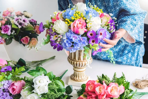 Молодая женщина-владелец цветочный жилет или аранжировка искусственных цветов жилет в ее магазине, ремесла и ручной работы концепции . — стоковое фото