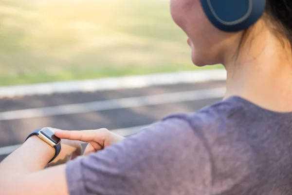 Donne esercizio al mattino utilizzando guardando sui suoi orologi intelligenti — Foto Stock