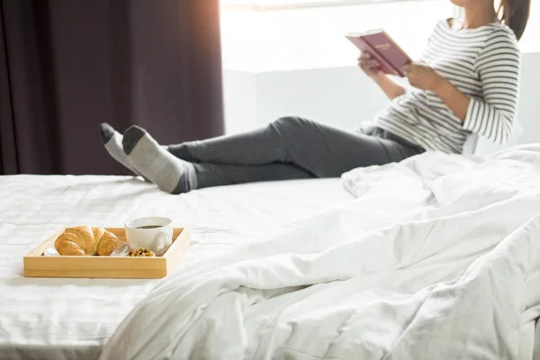 Mujer leyendo libro o periódico y tomando café desayuno en — Foto de Stock
