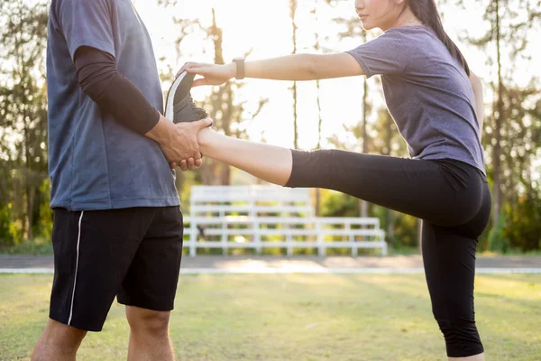 Early morning workout, Fitness couple stretching outdoors in par
