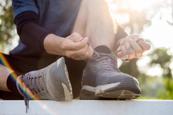 Atleta masculino atando cordones de zapatos en zapatillas minimalistas descalzas —  Fotos de Stock