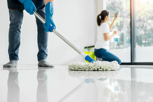 Young housekeeper cleaning floor mobbing holding mop and plastic — Stock Photo, Image