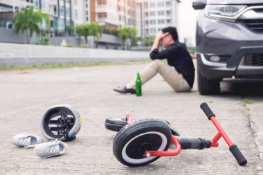 korkmuş ve şehir yolunda trafik kazası sonrası çocuk bisiklet ile otomobil kazasında araba önünde umutsuz sarhoş sürücü ve bira şişesi vurguladı