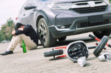 korkmuş ve şehir yolunda trafik kazası sonrası çocuk bisiklet ile otomobil kazasında araba önünde umutsuz sarhoş sürücü ve bira şişesi vurguladı