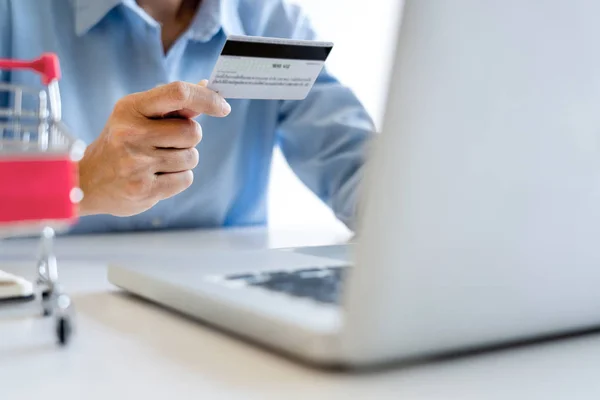 Homme tenant la carte de crédit en main et entrant le code de sécurité en utilisant — Photo