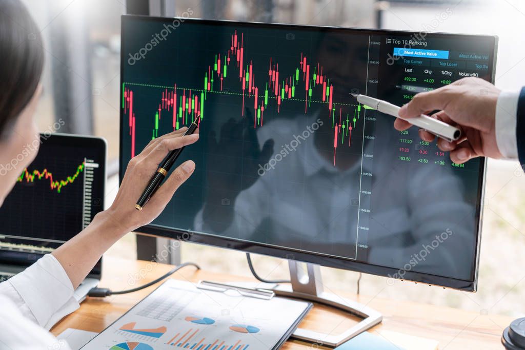 Team of stockbrokers Discussing with display screens Analyzing data, graphs and reports of stock market trading for investment 