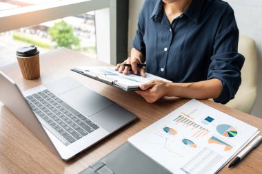 Dizüstü bilgisayar ve belgelerde grafik verileri ile çalışan iş adamı 