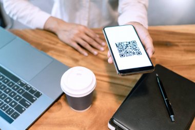 Ekranda Qr kodu ile akıllı telefon tutan adamın el, paymen