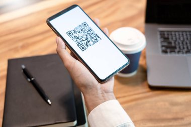 Ekranda Qr kodu ile akıllı telefon tutan adamın el, paymen