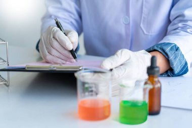 Bilim adamları laboratuvar önlüğü giyiyorlar ve koruyucu giysiler deney, laboratuvar ve geliştirme konseptinde deney tüpleriyle araştırma veya araştırma yapıyorlar..