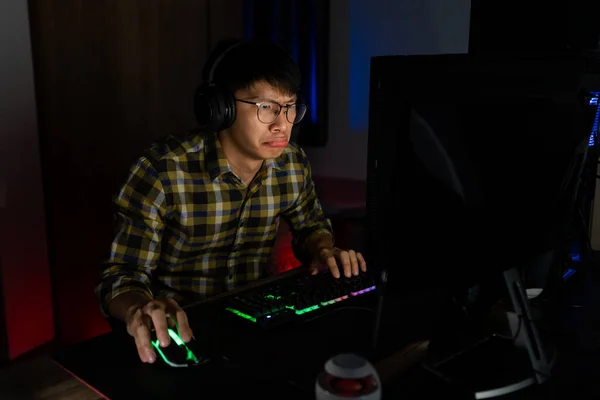 手で強調ヘッドフォンでアジアの男のゲーマーは コンピュータ上のビデオゲームを失うときに落ち込んでまたは怒ってショックを感じる間違い ビデオゲーム技術とEスポーツの概念のための恐怖と動揺 — ストック写真