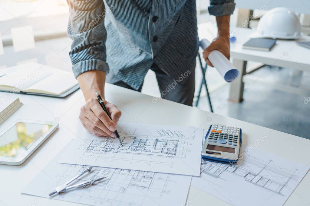 Confident engineer team working with Blue Print with architect equipment discussing and Planning work flow construction project. with partner at the table in office work site