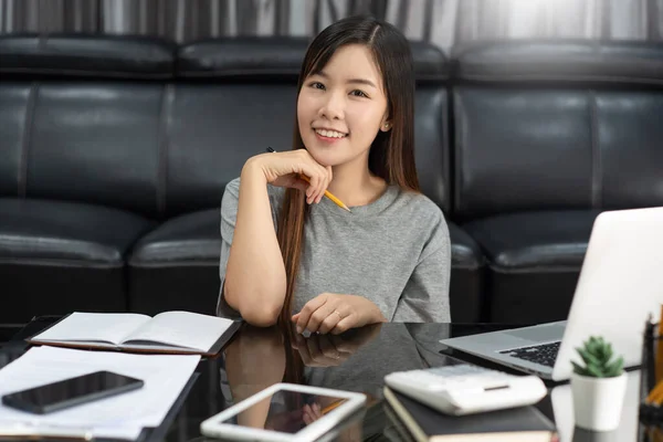 迷人的年轻美丽的亚洲女人 在室内客厅办公室做自由职业者 做电子教练 远程工作或在家工作时 带着笔记本电脑和文件工作 — 图库照片