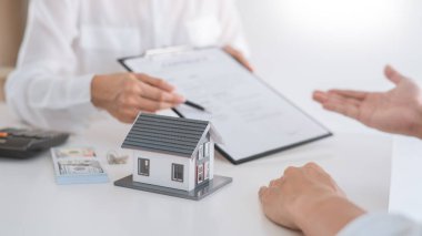 Emlakçılar, emlak konsepti almak, satın almak veya satmak için gelen müşterilere belgeleri açıklar.