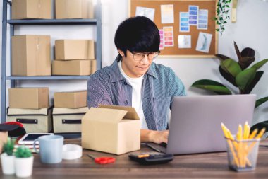 Karton kutuda çalışan Asyalı işadamı KOBİ girişimcisi veya serbest çalışan girişimci müşteri, çevrimiçi satış, e-ticaret, ambalaj ve nakliye kavramı için teslimat kutusu hazırlar