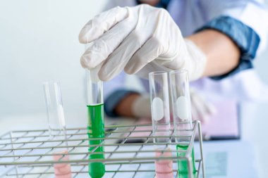 Bilim adamları laboratuvar önlüğü giyiyorlar ve koruyucu giysiler deney, laboratuvar ve geliştirme konseptinde deney tüpleriyle araştırma veya araştırma yapıyorlar..