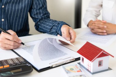 Emlakçılar, emlak konsepti almak, satın almak veya satmak için gelen müşterilere belgeleri açıklar.