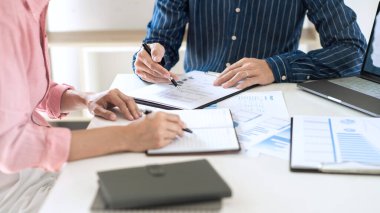 Toplantı ve başarılı takım çalışması konseptinde finansal belge grafikleri ve grafiklerini analiz eden yeni bir başlangıç projesiyle ofis masasında plan ile çalışan iş ekibi