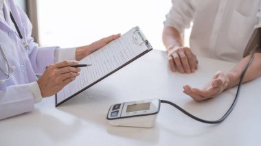 Hastanedeki hastanın kan basıncını, sağlık bakımını ve ilaç konseptini ölçen ve kontrol eden doktor