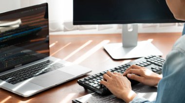 Programcı veya yazılım geliştirici Yeni Kod Satırları Yazıyor, kodlama teknolojileri ahşap endüstriyel iş yeri istasyonunda çalışıyor