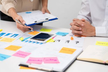 Girişim projesini planlayan iş adamları cam duvar, Strateji Analiz Ofisi Konsepti 'ne fikir paylaşmak için yapışkan notlar oturumu koyuyorlar