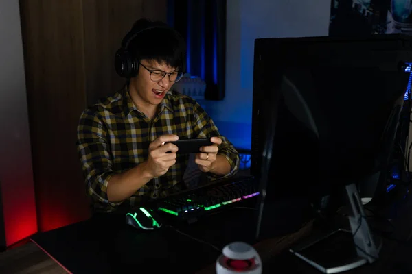 関与アジアの男性サイバースポーツゲーマーは 自宅で夜の暗い部屋でコンピュータ上でビデオゲームをプレイ集中しました Eスポーツと技術の概念 — ストック写真