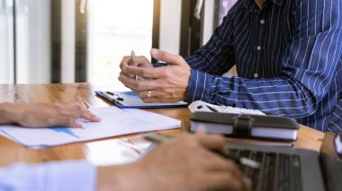 İş dünyası toplantısı, konferans masasında dizüstü bilgisayarı kullanarak modern ofiste iş projeleri hakkında fikir alışverişinde bulunuyor.