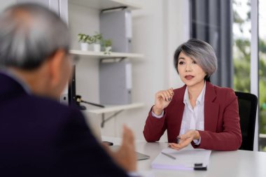 Professional Asian lawyer offers comprehensive legal counsel male client during crucial office meeting expert advice critical matters