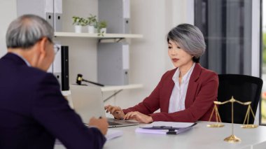 Asian female lawyer professional client meeting in modern law office providing legal advice expertise handling important documents consultation strategy