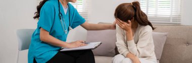 Asian medical professional offers comforting mental health consultation distressed woman private home therapy session