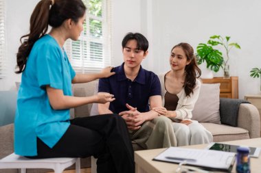 Expert therapist offers empathetic support Asian adult couple in their home promoting emotional well being and psychological guidance private