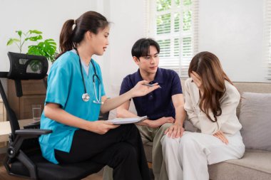 Professional medical consultation offered by an empathetic doctor to an Asian couple at home. Addressing emotional distress and providing support.