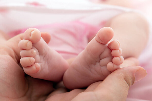 ноги новорожденного в перспективе на белом фоне
