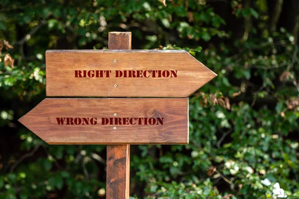wooden sign indicating right or wrong direction