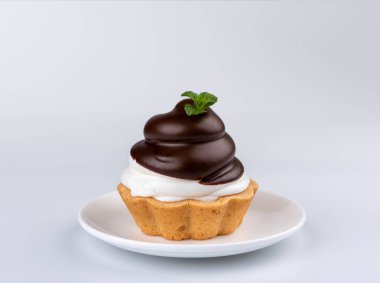 Beyaz zemin üzerine krem şanti ile küçük çikolata tart