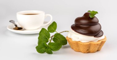 Krem şanti ve beyaz arka plan üzerinde kahve ile küçük çikolata tart