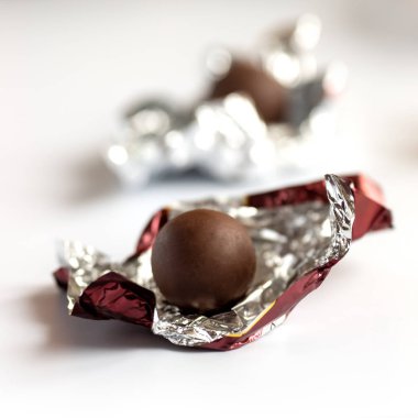 Çikolatalı pralin folyo sarılmış. Beyaz arka plan üzerinde izole