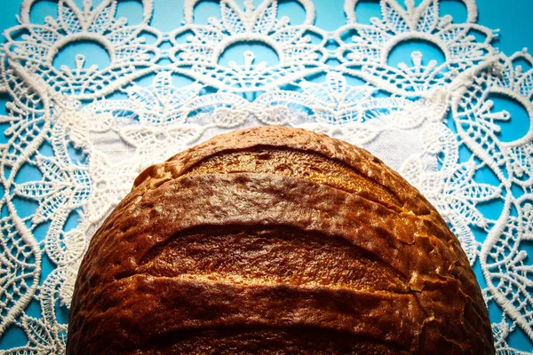 亚麻桌布上蓝色背景的新鲜圆形面包 — 图库照片