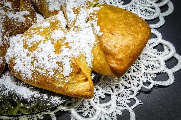 Kahverengi masada, masa örtüsünün üzerinde cam bir tabakta çay için taze bir çörek, pudra şekeri ve reçelli.
