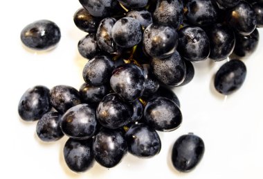 Taze koyu mavi üzümler, beyaz tabakta.